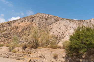 Güney İspanya 'da dağlık ve aşınmış bir arazi, bitki örtüsü var ve gökyüzü bulutlu.