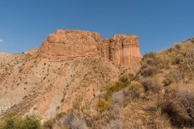 Güney İspanya 'da dağlık ve aşınmış bir arazi var, bitki örtüsü var ve gökyüzü açık.