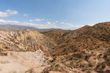 Güney İspanya 'da dağlık ve aşınmış bir arazi. Kuru bir vadi var, bitki örtüsü var ve gökyüzü bulutlu.