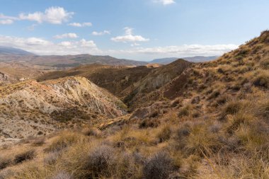 Güney İspanya 'da dağlık ve aşınmış bir arazi. Kuru bir vadi var, bitki örtüsü var ve gökyüzü bulutlu.