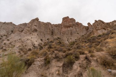 İspanya 'nın güneyindeki dağlık bölgede çalılar var, toprak aşınmış, gökyüzü bulutlu.