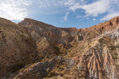 İspanya 'nın güneyindeki dağlık bölgede çalılar var, toprak aşınmış, gökyüzü bulutlu.