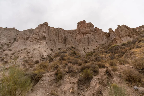 İspanya 'nın güneyindeki dağlık bölgede çalılar var, toprak aşınmış, gökyüzü bulutlu.