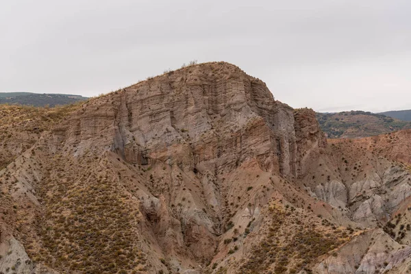 İspanya 'nın güneyindeki dağlık bölgede çalılar var, toprak aşınmış, gökyüzü bulutlu.