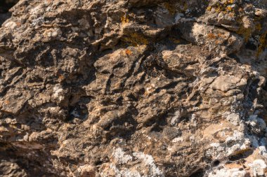 Kayaların düz olmayan yüzeyi, gri renkli kayanın yüzeyinde liken var.