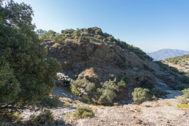 Sierra Nevada 'nın dağlık arazisi, ağaçlar ve çalılar var, taşlar ve kayalar var, bir kaya vadisi var, gökyüzü açık