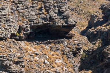 engebeli Sierra Nevada manzarası, bir kaya vadisi var, bir vadi var, çalılar var.