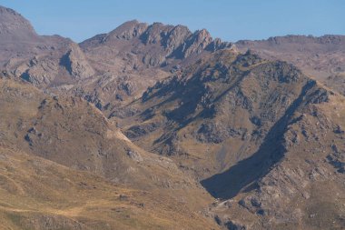 Sierra Nevada 'nın dağlık arazisi, çimenler ve çalılar var, taşlar ve kayalar var, gökyüzü açık.