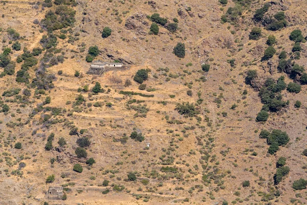 シエラネバダ山脈の山岳風景は 草や茂みがあり 石や岩ですが 山の中腹に農家があります — ストック写真