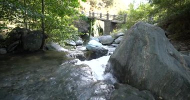 İspanya 'nın güneyindeki Sierra Nevada' da bir nehirden akan su. Taşlar ve kayalar var, bitki örtüsü var, köprü var.