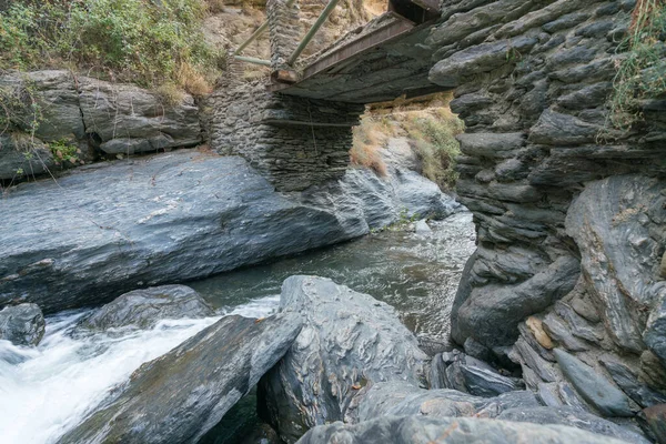南スペインのシエラネバダ川は 茂みや草ですが 岩や石があり 水はクリスタルクリアされ そこは川を渡る橋です — ストック写真
