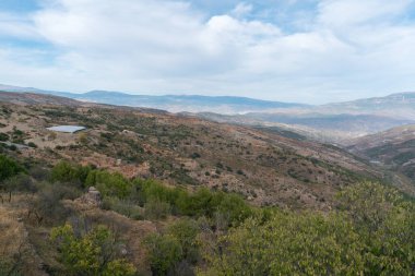 İspanya 'nın güneyindeki dağlık arazide çalılar ve kuru otlar var. Gökyüzü bulutlu.
