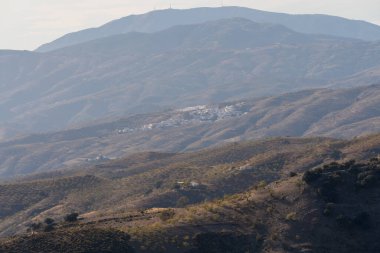 Dağ yamacında küçük bir kasaba, dağda badem ekimi var, birkaç vadi var..