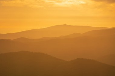 İspanya 'nın güneyindeki dağlarda gün batımında, gökyüzünde bulutlar, dağlarda ağaçlar var.