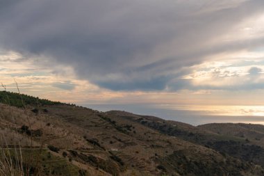 Güney İspanya 'nın dağlık arazisi, dağlarda ağaçlar, gökyüzünde bulutlar var.
