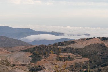 Güney İspanya 'nın dağlık arazisi, dağlarda ağaçlar, gökyüzünde bulutlar var.
