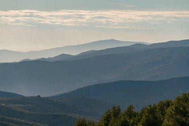 Güney İspanya 'nın dağlık arazisi, dağlarda ağaçlar, gökyüzünde bulutlar var.