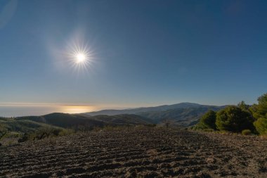 İspanya 'nın güneyindeki dağ manzarası. Dağların yamaçlarında ağaçlar var. Arka planda Akdeniz var.