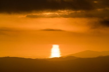 Güney İspanya dağlarında gün batımı, arka planda Akdeniz, gökyüzü bulutlu