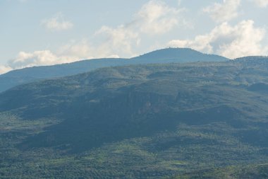 Güney İspanya 'nın dağlık arazisi, birkaç badem ve zeytin ağacı ekini, vadiler, gökyüzü bulutlu.