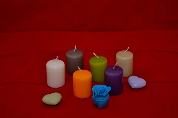 一套彩色蜡烛 两颗心 红色背景上有一朵蓝色的花 — 图库照片