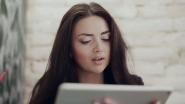 Kadın Holding dijital Tablet ve kapuçino ahşap bir masa üzerinde