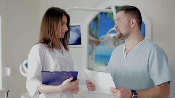 Zwei medizinische Mitarbeiter kommunizieren über Themen. — Stockvideo
