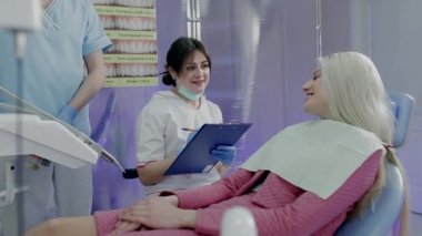 Hekim dişçi ofisinde hastada hakkındaki bilgileri kaydeder