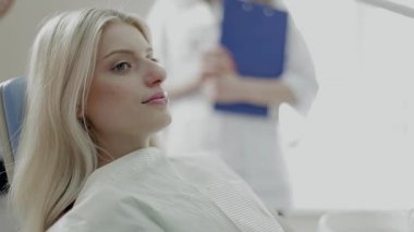 Hastanın duran Office diş asistanı güzel kız. Güzel kız lazer tarafından muayene