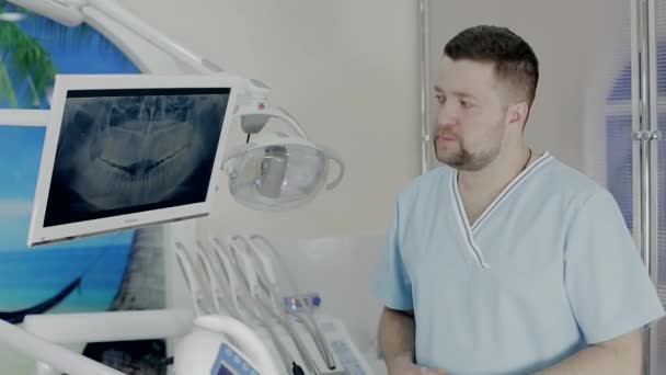 Le médecin se tient près du moniteur et examine les dents — Video