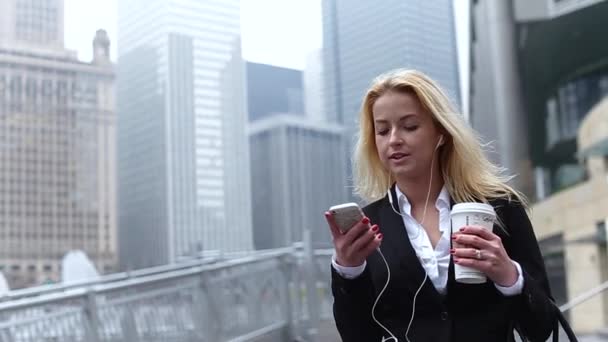 Krásné mladé ženy mluví po telefonu proti komplex moderních kancelářských budov. — Stock video