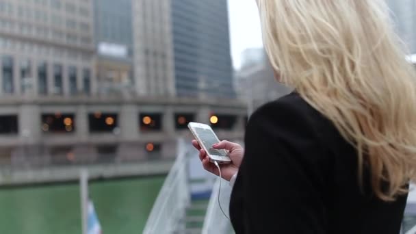 Hermosa mujer de negocios de raza mixta caminando por la ciudad conectada con el teléfono inteligente — Vídeo de stock