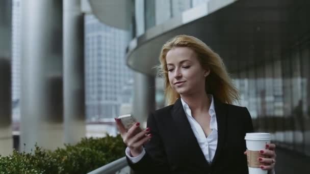 Pretty Young Business Woman Talking by Phone Against Complex of Modern Office Buildings. — Stock Video