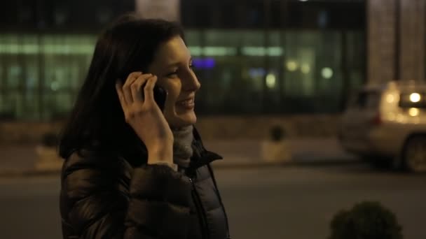 Chica caminando en el camino por la noche con un teléfono — Vídeo de stock