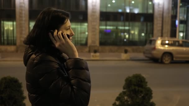 Meisje lopen op de weg 's nachts in de buurt van de telefoon winkels — Stockvideo