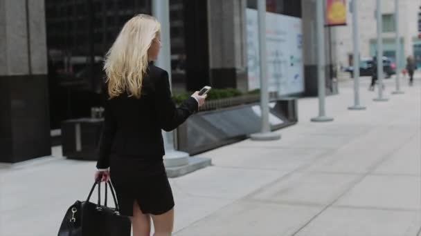 Γυναίκα σε εργασία αρκετά νεαρός μιλώντας από τηλεφώνου εναντίον συγκρότημα με σύγχρονα κτίρια γραφείων. — Αρχείο Βίντεο
