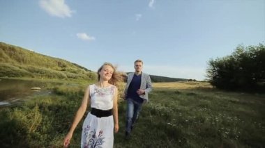 aşık genç bir çift ile onların evde beslenen hayvan köpek güzel bir orman yoluyla birlikte yürüyoruz. ağır çekim.