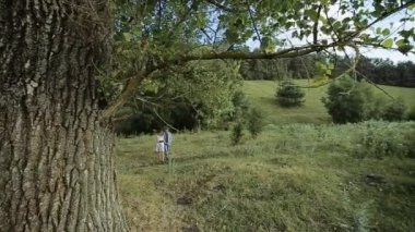 aşık genç bir çift ile onların evde beslenen hayvan köpek güzel bir orman yoluyla birlikte yürüyoruz. ağır çekim.