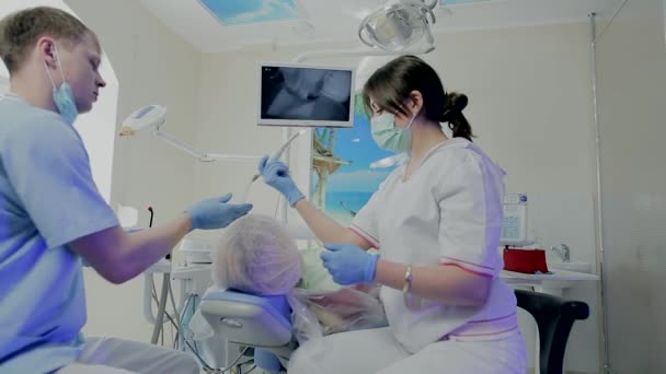 Zwei Ärzte, die in der Zahnmedizin operieren und Zähne untersuchen die Kamera . — Stockvideo