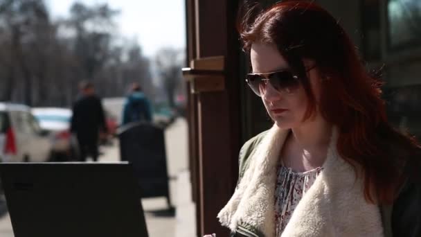 Flicka arbetar vid datorn i gården, Sonyachnyts dag tjejen i glasögon — Stockvideo