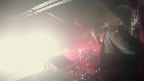 DJ toca na discoteca, dançando pessoas no fundo — Vídeo de Stock
