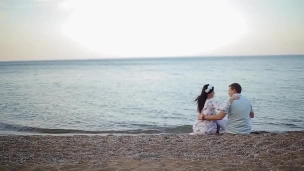 Haar schöne Mädchen streichelt ihren Liebhaber und sitzen auf dem Sand — Stockvideo