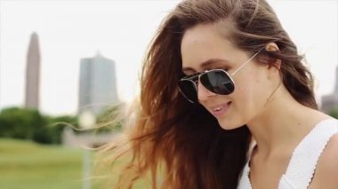 Güzel kız ile dövme beyaz gömlek ve siyah güneş gözlüğü olduğunu iskambil ile Her Kahverengi saç ve aygıt yavaş hareket