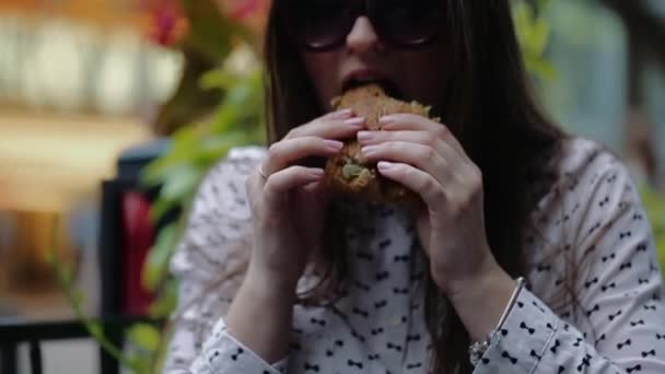 Gyönyörű lány eszik hamburgert az utcán a Chicago — Stock videók