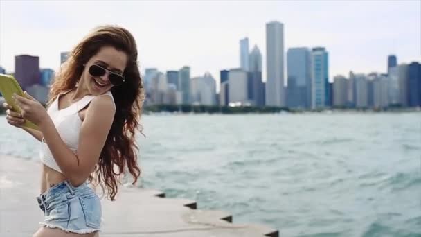 Aranyos vékony lány Ugrás a készüléket neki kezét előtt Downtown-lassú mozgás — Stock videók