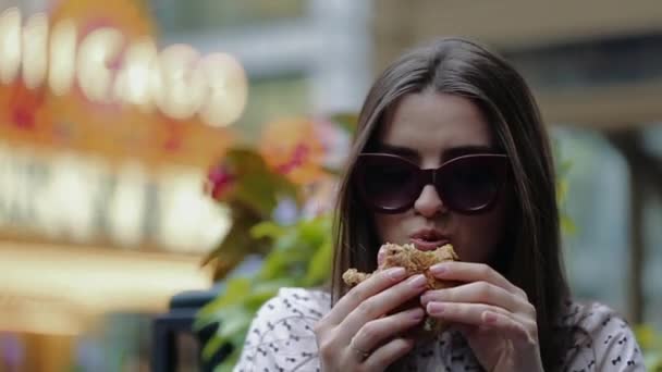 Gyönyörű lány eszik hamburgert az utcán a Chicago — Stock videók