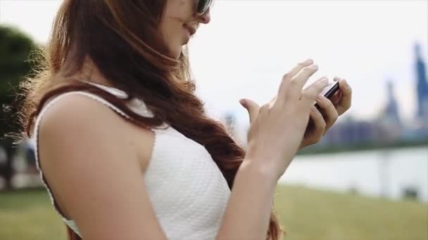 Kavkazská dívka se dívá na její telefon hledání volání v její seznamu kontaktů. — Stock video