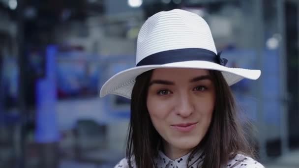 Hermosa mujer joven con sombrero sonriendo y dice activamente mirando recto . — Vídeo de stock