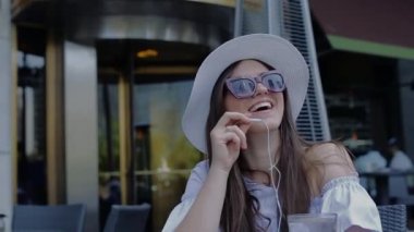 Güzel genç kadın Talking telefon gülümseyerek oturan Cafe dışında olduğu.