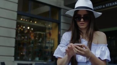 Genç kadın arama numarasına cep telefonu gülümseyerek oturan Cafe dışında açıktır.
